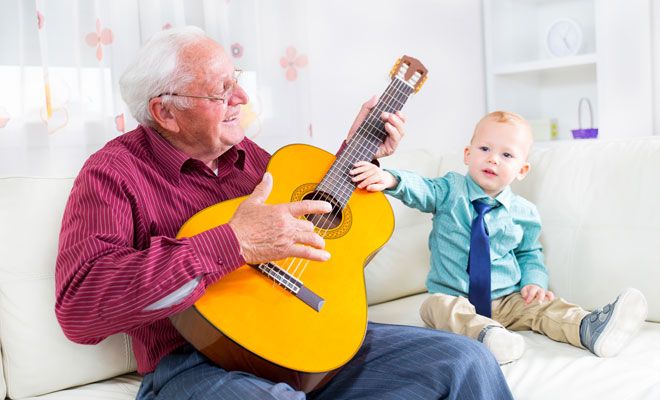 Opa mit einer Gitarre neben seinem Enkel